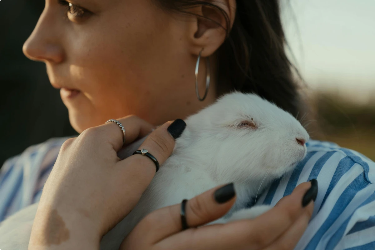 Kvinde som holder en hvid kanin i hendes arme